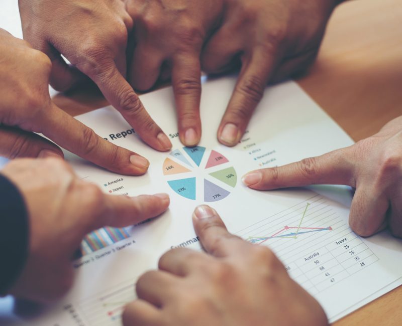 Group of business partners discussing ideas analysis and planning work in office.